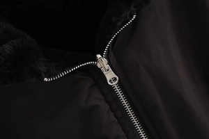 Close-up of a premium black bomber jacket featuring a metal zipper and soft faux fur lining