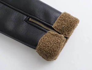 Détail d'une veste en similicuir noir avec doublure sherpa brune et zip en bronze