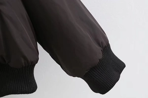 Close-up of black ribbed cuffs on a windproof bomber jacket with smooth fabric detail