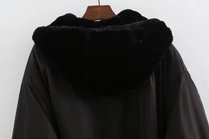 Detail view of a black Y2K puffer jacket featuring a plush faux fur hood and matte fabric