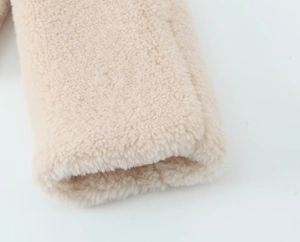 Detailed macro view of the warm beige fleece fabric texture on this women's jacket