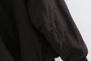 Detailed close-up showing stitching and elastic cuff of the black Y2K bomber jacket