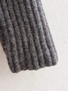 Détail macro de la robe en maille marron café avec texture côtelée et fibres de laine douces