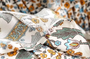 Detailed macro view showing high-quality stitching and boho floral print on the fabric seam