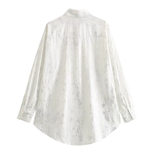 Detail of loose-fit Y2K white shirt with metallic silver texture and asymmetric hemline