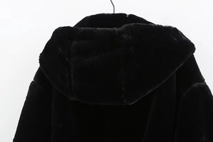 Detailed back view of a plush black faux fur hooded jacket with premium oversized hood