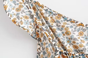 Detail of adjustable silver buckle and floral fabric on summer spaghetti strap dress