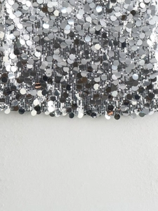 Nahaufnahme von glitzernden silbernen Pailletten mit metallischem Spiegeleffekt für Röcke