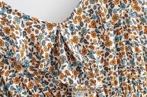 Detail shot of the ruffle neckline and floral print fabric on the summer dress
