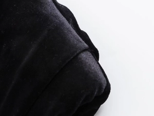 Macro shot of high-quality black velvet fabric texture with soft glossy sheen and fine stitching
