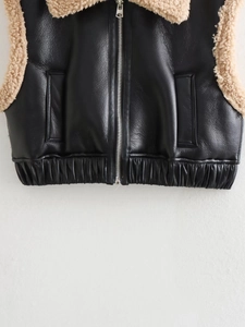 Détail de veste Y2K en similicuir noir avec col en peau de mouton beige et fermeture éclair