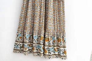 Detailed close-up of Bohemian floral skirt hem with orange ruffles and vintage print