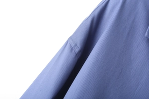 Vue détaillée montrant les coutures précises et la texture du tissu popeline rayé bleu
