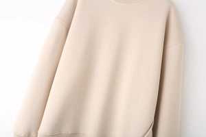 Close-up of beige crewneck sweatshirt showing thick cotton fabric texture and ribbed hem