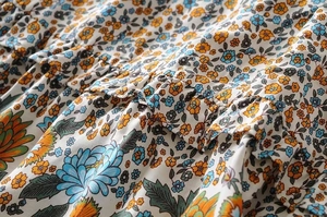 Detailed macro view of the floral print fabric and ruffled pleats on the dress