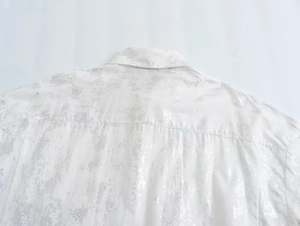 Detail of white Y2K shirt featuring metallic silver distressed texture and collar