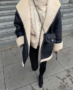 Dettaglio outfit invernale con giacca shearling nera e maglione in maglia a trecce