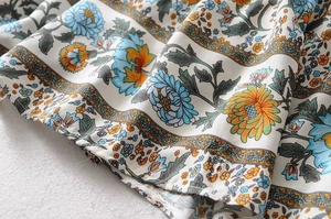 Detailed macro view of bohemian floral print fabric with blue and orange flower patterns