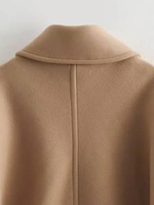 Close-up of camel wool coat showing the high-quality twill texture and collar stitching
