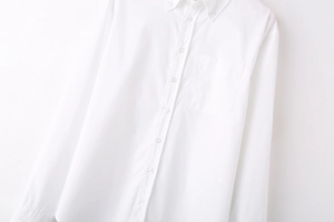 Detailed view of white long sleeve shirt featuring button-down collar and chest pocket