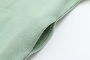 Macro view of side pocket stitching on mint green cotton oversized hoodie