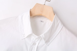 Close-up of white Y2K style shirt collar with S size tag and translucent buttons