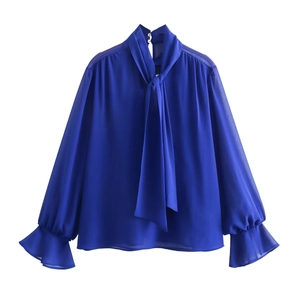 Detail of royal blue chiffon blouse showing tie-neck bow and ruffled elastic cuffs