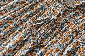 Detail of ditsy floral print dress with drawstring and ruffles on ivory fabric