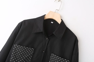 Detail of black poplin shirt featuring silver stud pockets and pointed collar