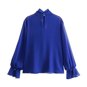 Detail of royal blue chiffon blouse with ruffled cuffs and button accents