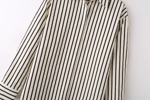 Close-up detail of the vertical black and white stripes and button-down collar of the shirt