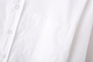 Detail of front pocket and transparent button on a white long-sleeved shirt