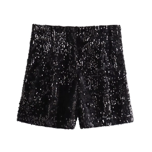 Dettaglio di pantaloncini neri di paillettes a vita alta con texture lucida da festa