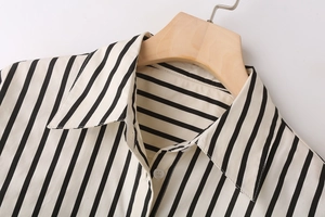 Macro detail of vertical black and white stripes and white buttons on poplin shirt