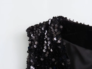 Detailed macro view of black sequins stitched on fabric with premium smooth lining