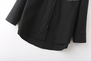 Detail of black poplin shirt with metallic rivet accents and layered curved hemline