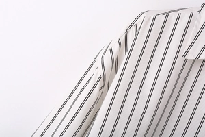 Macro shot of vertical striped fabric texture and shoulder seam on a minimalist shirt