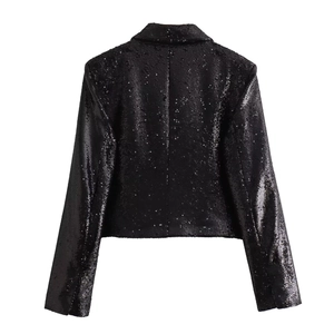 Detail view of the back of a black sequined suit jacket with shiny metallic texture