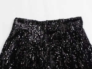 Vista macro dettagliata delle decorazioni con paillettes nere sugli shorts Y2K a vita alta