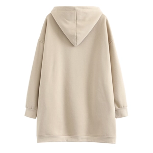 Detail view of the back of a beige oversized cotton hoodie with ribbed hem and cuffs