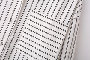 Macro shot of vertical striped fabric with a horizontal stripe chest pocket and button