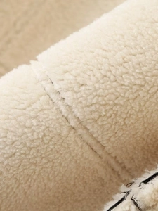 Dettaglio ravvicinato della trama in shearling color crema e cuciture su giacca in PU