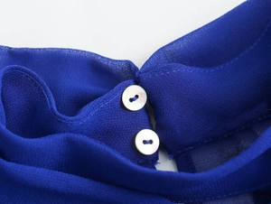 Detail of royal blue chiffon blouse showing back collar with double pearl buttons
