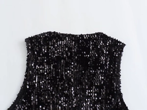Close-up detail of dense black sequins sewn on fabric of this vintage style vest