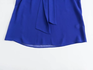Detail shot of bright blue chiffon hemline with delicate tie straps and sheer fabric