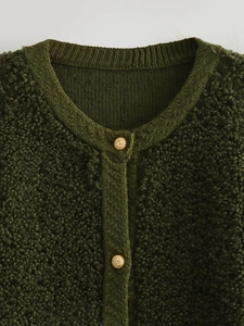 Cropped shot of dark green bouclé knit cardigan featuring ornate gold lion head buttons