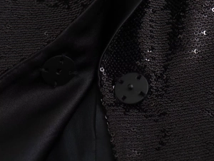 Macro shot of shimmering black sequins on Y2K French cardigan with round button detail