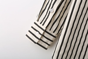 Detailed macro view of striped poplin shirt cuffs with fine stitching and white buttons
