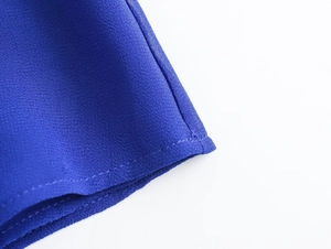 Macro shot of dark blue blouse hem featuring high-quality chiffon fabric texture and neat stitching
