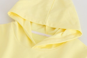 Détail du col d'un sweat à capuche jaune clair avec ruban blanc et coutures fines